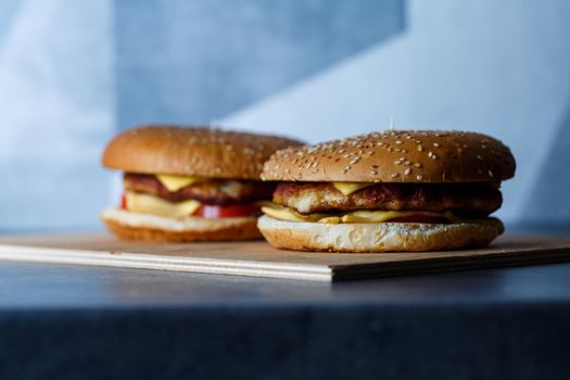Large juicy burger with cutlet cheese and tomatoes. Fast food