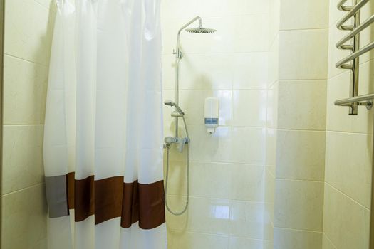 Bright bathroom with shower, shower head, light tile