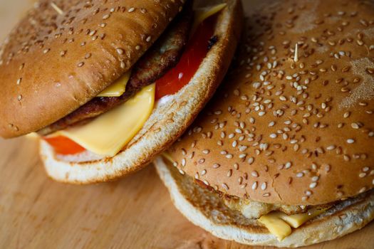 Large juicy burger with cutlet cheese and tomatoes. Fast food
