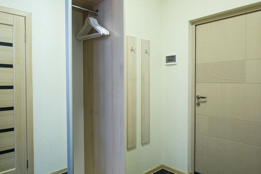Long bright entrance hall with doors in a new hotel with wardrobe