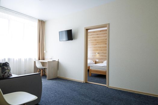 Bright lounge in the hotel with doors, armchair, TV
