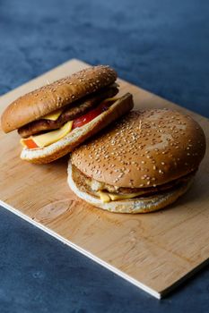 Large juicy burger with cutlet cheese and tomatoes. Fast food