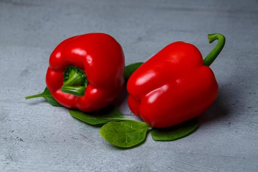 Red pepper with spinach on a gray table