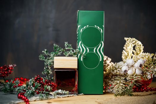 Perfume bottle New Year's gift. Stylish New Year decor perfume bottle is under the tree. Fashionable perfumes in New Year's locations. Perfumes for women