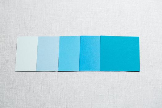 square pieces of multi-colored fabric laid out on a gray background