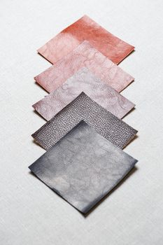square pieces of multi-colored fabric laid out on a gray background