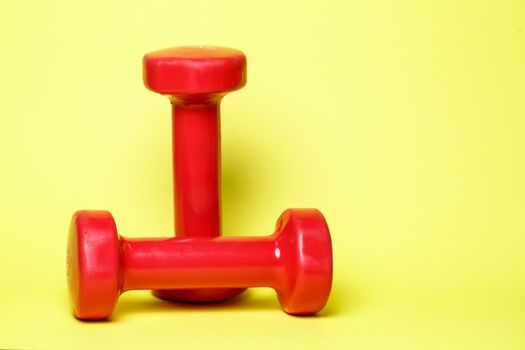 red sports dumbbells on a yellow background