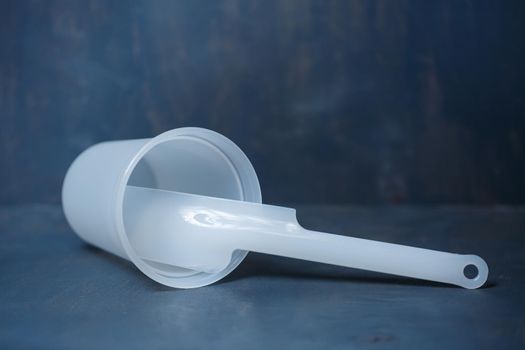 Plastic glass for mixing cream on a gray background