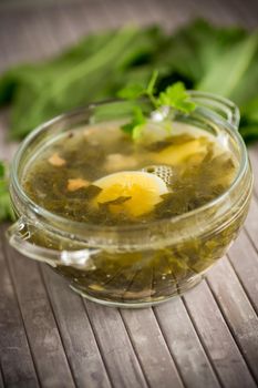 Spring soup from fresh sorrel with boiled eggs in a plate on a wooden table