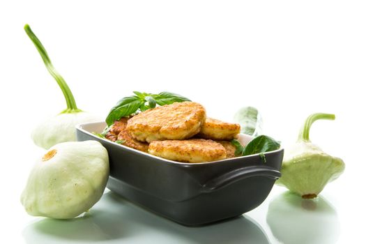 fried vegetable pancakes from squash and zucchini with greens, isolated on a white background.