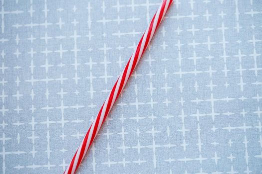 Plastic reusable straw for cocktails on a gray background