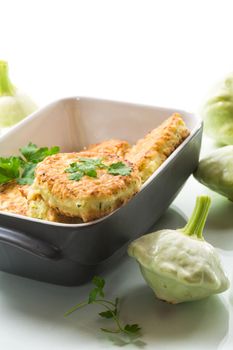 vegetable fried squash and zucchini cutlets in a ceramic form isolated on a white background