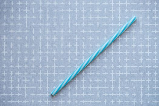 Plastic reusable straw for cocktails on a gray background