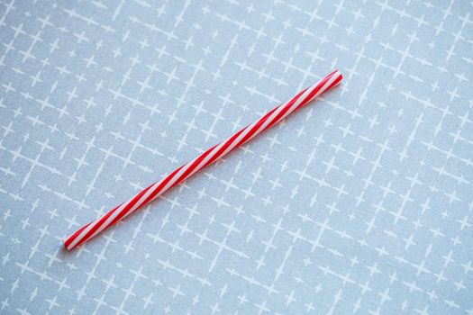 Plastic reusable straw for cocktails on a gray background