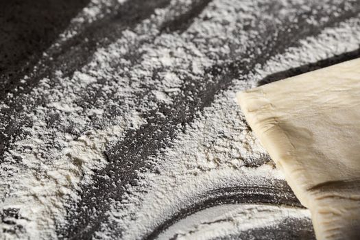 Baking flat lay on the table the dough, flour on a gray background. Bake menu, recipe, home baking concept. Top view with copy space for your text.
