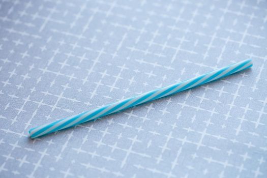 Plastic reusable straw for cocktails on a gray background