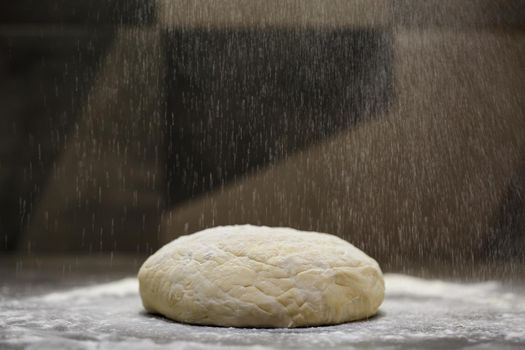flour dough for baking cookies on the kitchen table