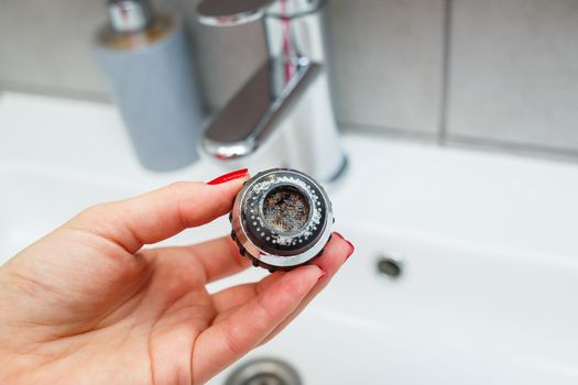 Rotary nozzle on the mixer to adjust the flow of water. White bathroom sink for washing hands