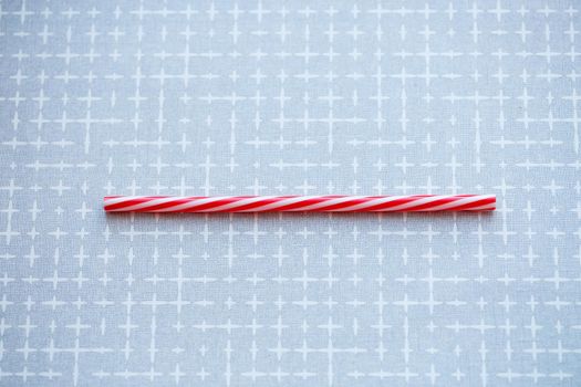 Plastic reusable straw for cocktails on a gray background