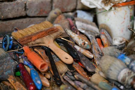 Many used dirty brushes of the artist in the workshop