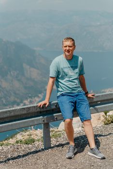 Man tourist enjoys the view of Kotor. Montenegro. Bay of Kotor, Gulf of Kotor, Boka Kotorska and walled old city. Travel to Montenegro concept. Fortifications of Kotor is on UNESCO World Heritage