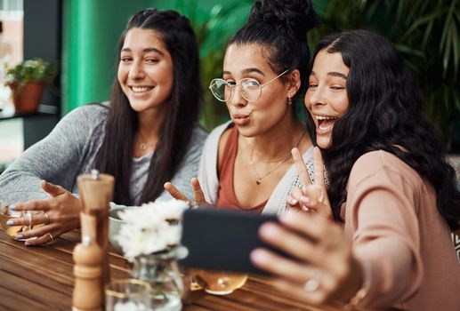 Every moment together is a moment worth capturing. young sisters taking selfies together at a cafe