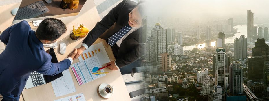 Group business people handshake at meeting table in widen view in office together with confident shot from top view . Young businessman and businesswoman workers express agreement of investment deal.