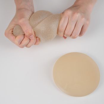 Caucasian woman testing the strength of a breast implant