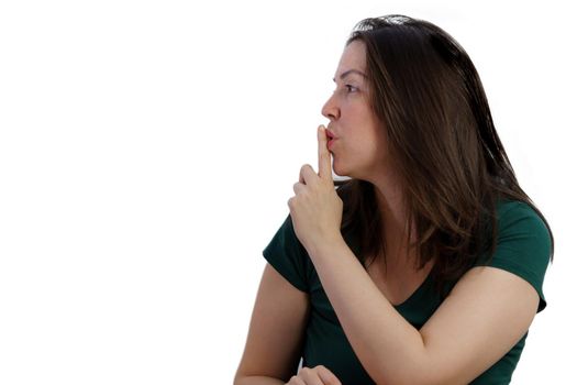 close-up of young girl with finger on mouth in profile asking for silence isolated on white background