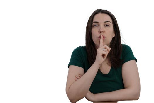 close-up of young girl with finger on mouth asking for silence isolated on white background