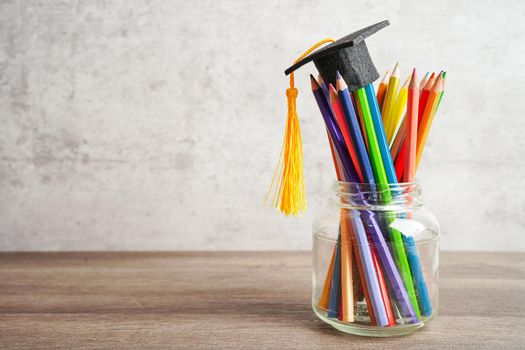 Graduation hat with colorful pencils on book with copy space, learning university education concept.