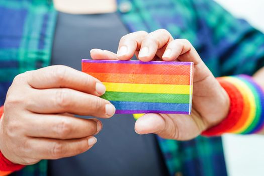 Asian woman with rainbow flag, LGBT symbol rights and gender equality, LGBT Pride Month in June.