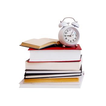 close-up, a stack of colored old books and an alarm clock on it, an isolated object on a white background. School concept, online learning, homework, time