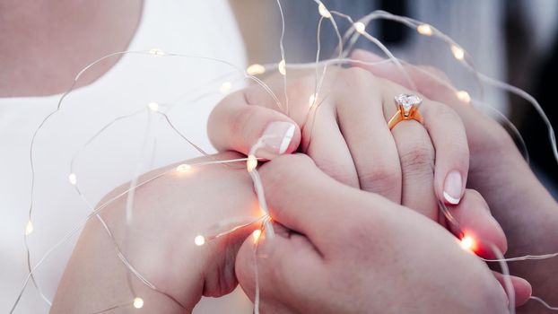 Close up ans soft focus selective ring. Wedding photograph young couple of lovers who are just married, are close to each other in harmony, love and happiness. Groom holds the bride's hand in his hand.