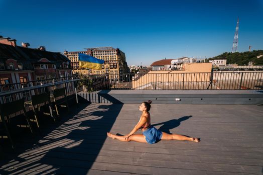 Young woman practicing yoga on the roof