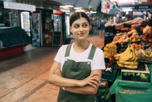 A woman seller of fruit at the market near the counter with fresh goods