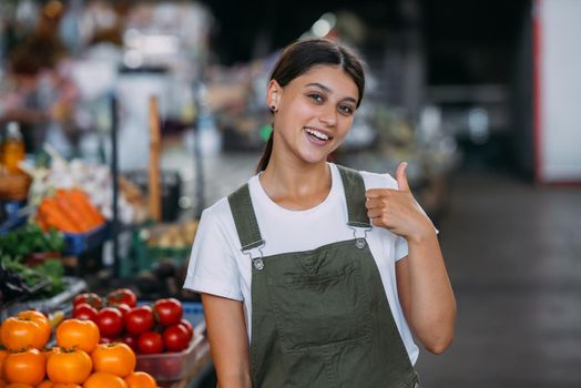 Woman seller at the counter with vegetables.