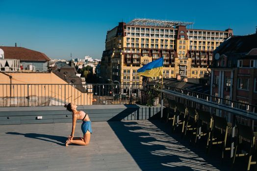 Young woman practicing yoga on the roof