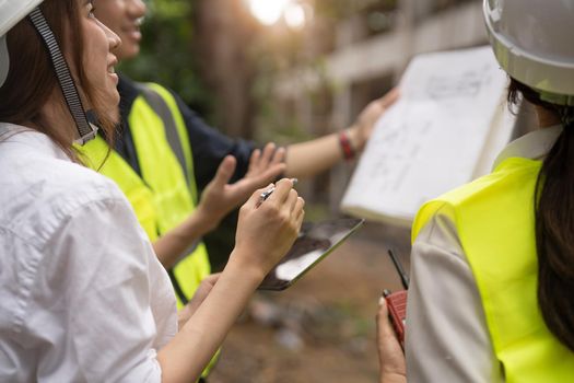 Engineer and Architect working at Construction Site with blue print, Construction concept