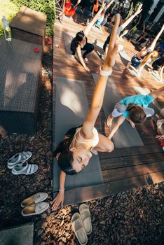 A woman does yoga together with her group in the open air. Healthy lifestyle concept