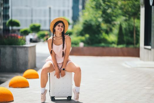 Lifestyle and travel Concept: Young beautiful caucasian woman is sitting on suitecase
