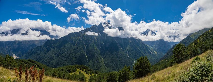 Panorama of mountains with beautiful clouds and waterfalls in North Ossetia