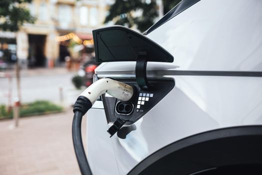 Close up of the power supply plugged into an electric car being charged.