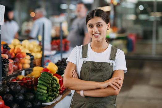 A woman seller of fruit at the market near the counter with fresh goods