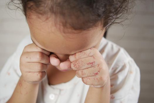 sad upset child girl crying against gray background .