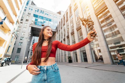 Young female blogger with smartphone streaming on the street. Close view