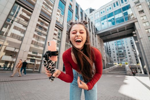 Young female blogger streaming on the street. Close view