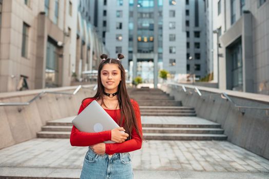 Beautiful young woman on the street and working using computer laptop