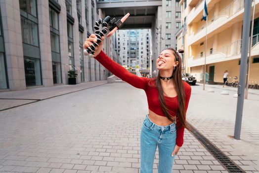 Young female blogger with smartphone streaming on the street. Close view