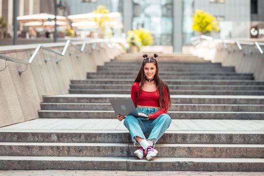 Beautiful young woman on the street and working using computer laptop